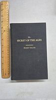 Front cover of the book titled 'The Secret of the Ages' by Robert Collier with ruler for size context.