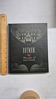 Front cover of Batman Murder at Wayne Manor book with ruler for size reference.