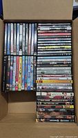 Top view of boxed lot showing 59 assorted DVDs arranged in rows.