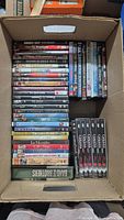 Top-down view of the full lot of DVDs in a cardboard box.