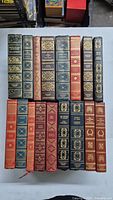 Photo showing all 15 vintage hardcover books with decorated spines and different colors.