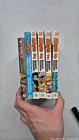 Front view showing spines of six manga books including Naruto volumes 1, 2, 3 and 4 with two miscellaneous books.