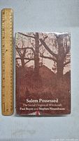 Front cover of vintage 1970s hardcover book titled 'Salem Possessed: The Social Origins of Witchcraft', showing sepia-toned trees and a house, with a ruler beside it.