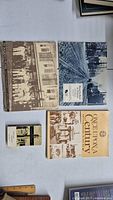 Full view of the lot with four books and a booklet arranged on a white surface showing covers with historical images and text.