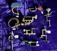 Overview of eight metal sewing clamps on purple fabric