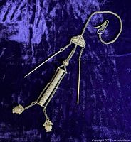 Full view of the Chinese silver chatelaine laid on a purple fabric background, showing the central compartment, dangling fruit charms, and attached chains.
