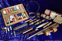 Overall lot showing wooden thread carrier with many spools, crochet hooks, embroidery hoops, roll-ups and assorted sewing tools.