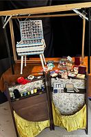 Photo of entire lot including embroidery stand, hardwood travel cabinet, needlecases, thread spools and other sewing accessories