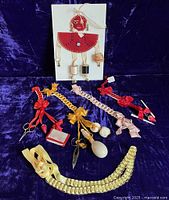 Group photo of all items including sewing puppet on card and various ribbon chatelaines with sewing tools