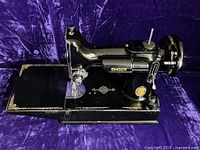 Singer 221 Featherweight machine on purple fabric, worksurface extended.