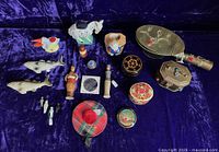 Overview of all included souvenirs and sewing-related small collectibles displayed on dark purple velvet background.