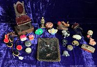 Overall array of novelty tape measures and pincushions on blue velvet