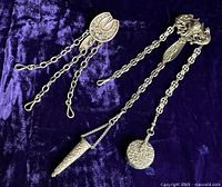 Both chatelaines laid out showing chains and belt clasps.