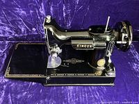 Singer 221 Featherweight sewing machine on purple velvet background