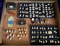 Top-down view of vitrine contents showing trays of thimbles and accessories