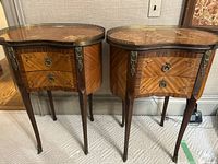 Pair of kidney-shaped bedside tables side by side against wall