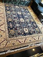 Angled view of full rug beneath seating showing overall pattern and border condition