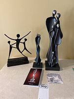 Group shot of all three sculptures on table with auction tag and documentation