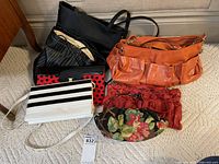 Collection of six ladies purses in various colors and sizes arranged together