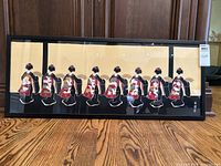 Full view of the framed fabric artwork showing seven women in traditional kimonos along the bottom of the frame.