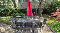 Full set, including table, eight chairs, side table, red umbrella and stand in garden setting