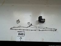 Long silver chain with bead accents, heart-shaped pendant, and pair of green stud earrings in a black box on white surface.