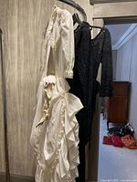 Photo of off-white Lori Ann long-sleeve dress with lace and ruffles hanging on a door
