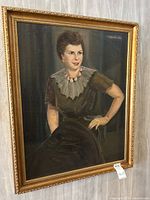 Framed oil painting portrait of a woman signed Flermoris 1936, showing seated woman in dark dress with a pleated collar and pink necklace.