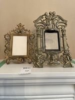 Overview photo showing both the smaller bronzed gold ornate frame and the larger bronzed frame with figures
