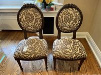 Pair of antique Lori Morris parlour chairs showing overall front view and placement on wooden floor near window and wall.