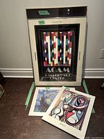 Large 35x24 colorful geometric abstract Agam Gallery Art Center framed poster with two smaller framed posters in front, Picasso 20x16 and Monet 16x20.