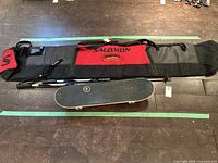 Full lot with Salomon ski bag, Capix skateboard, and Swix ski poles displayed on floor