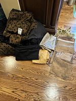 Photo showing folded black and gold polka dot fabric runners with solid black and gold fabric pieces and several sheer shimmer gold napkins.