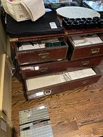 Drawers open showing linens and napkin rings on top with visible wear on wooden furniture.