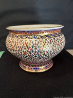 Full side view of Benjarong ceramic bowl showing intricate multicolor traditional hand painted designs with gold highlights and broad opening.