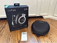 Veho Z-8 dual acoustic headphones packaging box and headphone case on wooden floor.