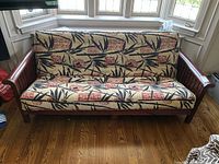 Front view of futon showing wooden frame and patterned cushions.