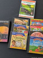 Top view of assorted software discs and cases including Webroot Internet Security and educational titles like IBM Brain Bytes and Fisher-Price.