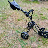 Side angle showing full profile of Bag Boy foldable golf cart with wheels and handle.