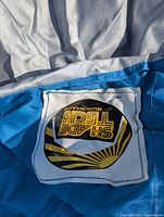 Close-up of Shade Tech by QuikShade label on blue canopy fabric.