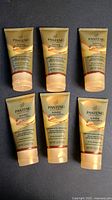 Six tubes of Pantene Gold Series Hydrating Butter-Crème arranged in two rows of three on a dark surface.