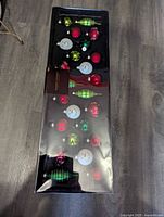 Full set of 24 assorted blown glass Christmas ornaments inside original packaging, showing a mix of red, green, and white ornaments