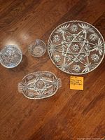 Photo showing the full set including the large serving platter, oval relish dish, small sherbet bowl, and candy dish with Star of David cut glass design.