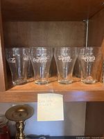 Set of 4 Coca Cola drinking glasses showing several logo varieties
