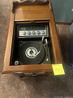 Top view of the open small end table showing turntable and radio controls inside.