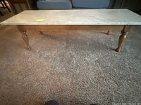 Full view of coffee table showing stone top, wood frame and legs