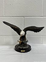 Front view of the American Bald Eagle figurine showing detailed eagle with spread wings mounted on dark wooden base.