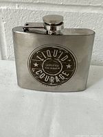 Front view of stainless steel flask showing Liquid Courage Gin logo with stars and wording.