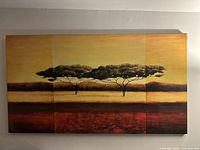 Full view of the large rectangular African themed painting featuring two acacia trees in a yellow-orange and brown sunset background.