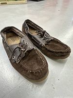 Pair of brown corduroy Aldo loafers with multi-colored stripes, lace-up moccasin style visible in photo